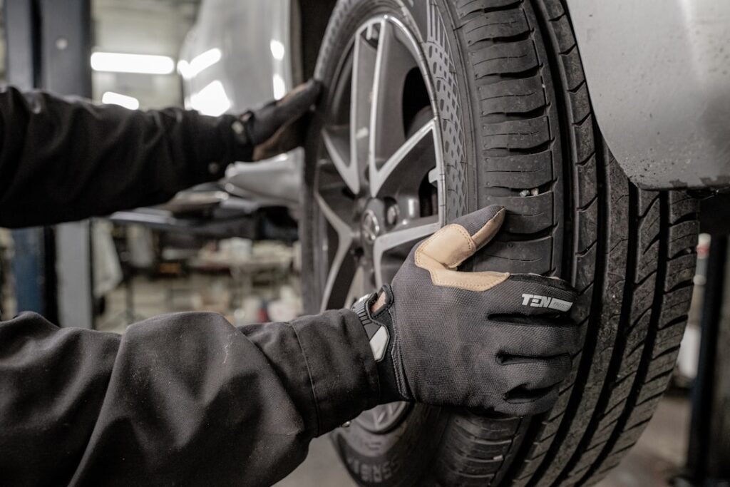Mechanic in work gloves changing a vehicle tyre